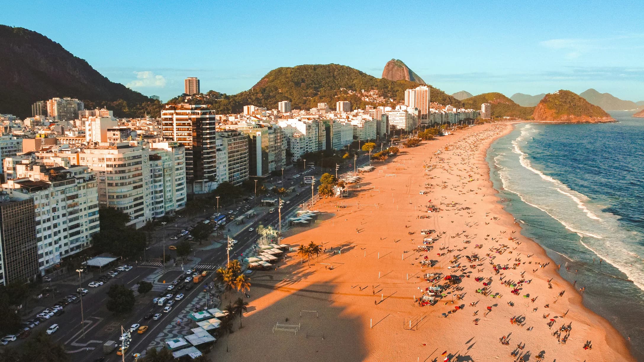 Vista aérea de la playa de Copacabana, con la avenida, los edificios frente al mar y los morros al fondo
